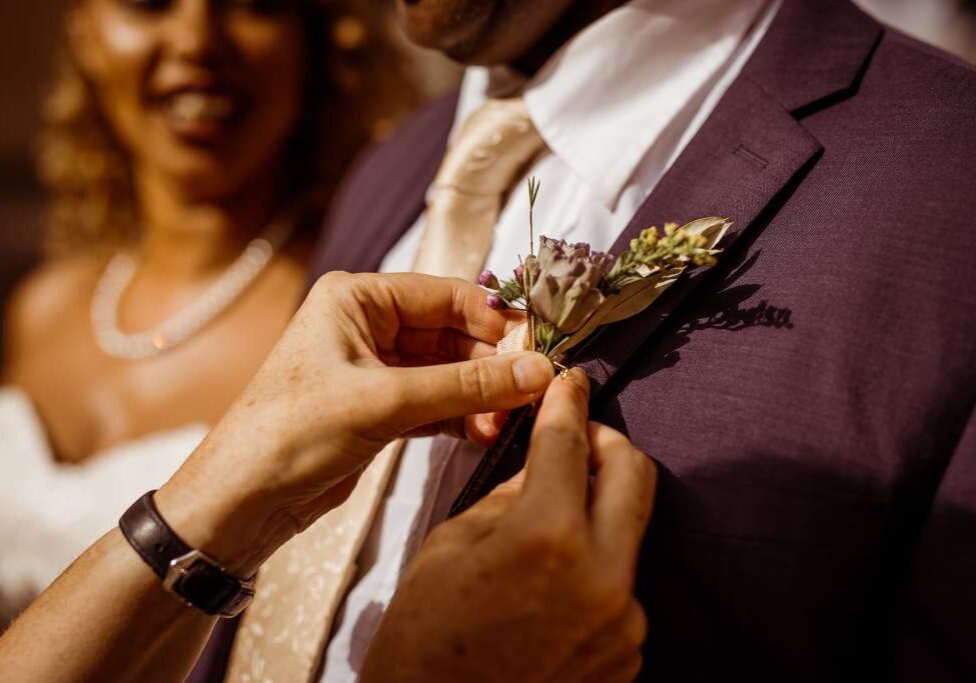 A buttonhole is attached to the bride's father's lapel